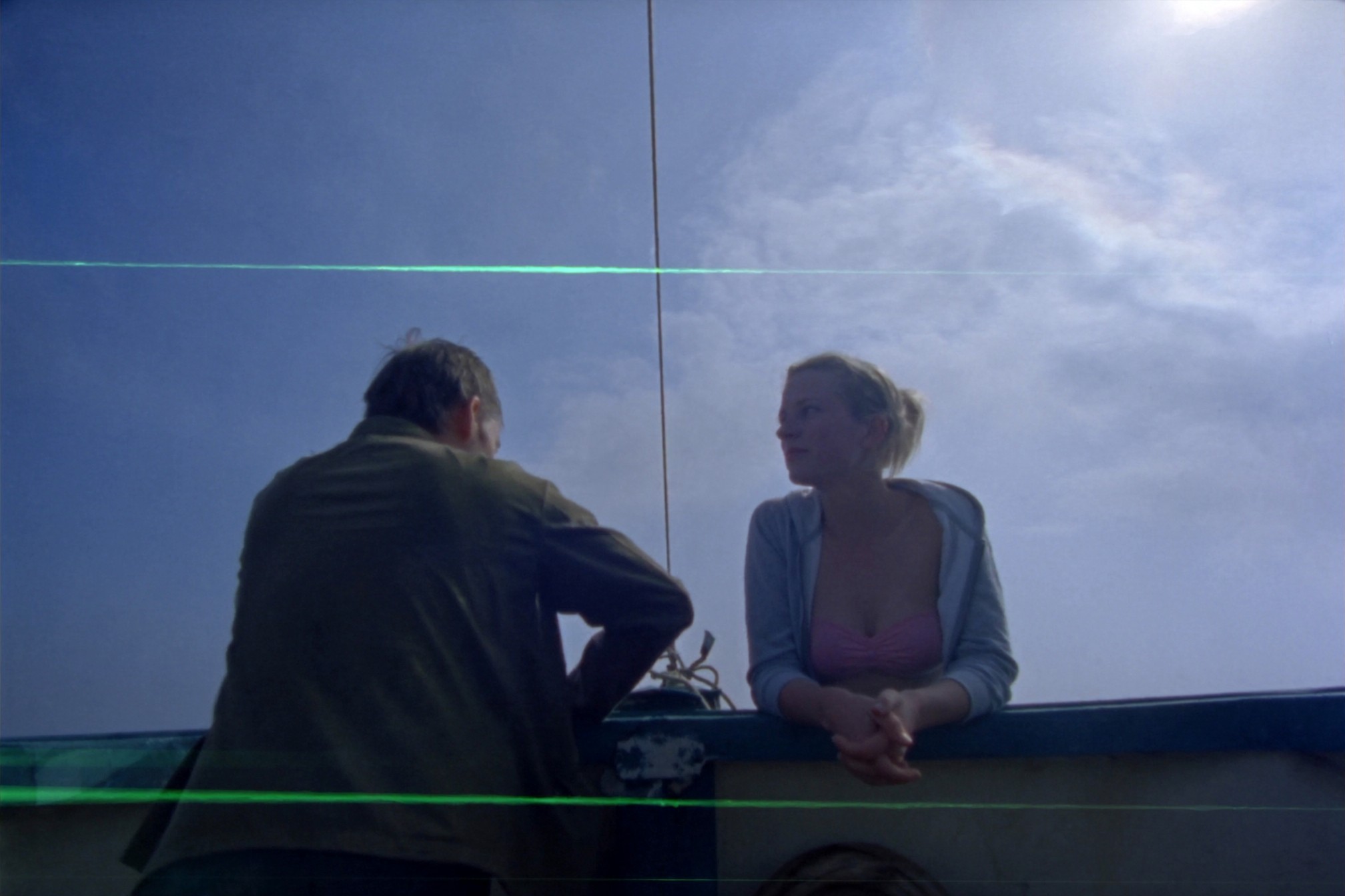 Two people talking on a boat in open water